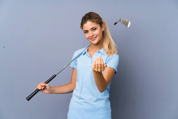 青少年高尔夫球手女孩在灰色的墙上邀请来与手 很高兴你来了 — 图库照片