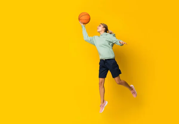 Adolescente Bola Basquete Menina Saltando Sobre Fundo Amarelo Isolado — Fotografia de Stock
