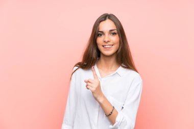 İşaret parmağı ile işaret izole pembe arka plan üzerinde genç kadın harika bir fikir