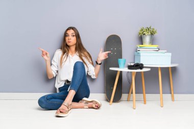 Yerde oturan genç kadın yan taraftakileri işaret ediyor. Şüpheleri var.