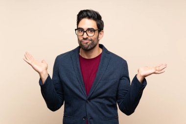 El kaldırırken şüpheleri olan izole arka plan üzerinde Yakışıklı genç adam