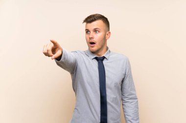 Izole arka plan üzerinde genç sarışın işadamı uzağa işaret