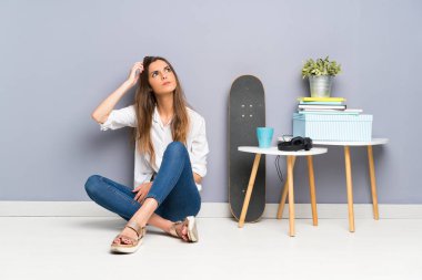 Genç kadın şüpheler ve karışık yüz ifadesi ile katta oturan