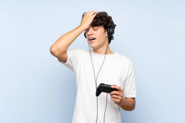 Jongeman Speelt Met Een Videogame Controller Geïsoleerde Blauwe Muur Heeft — Stockfoto