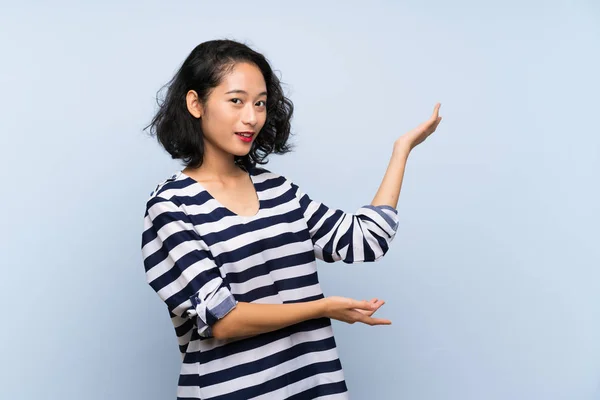 Asiatico Giovane Donna Oltre Isolato Blu Sfondo Estendendo Mani Lato — Foto Stock