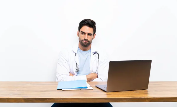 Jovem Médico Homem Com Seu Laptop Sobre Parede Isolada Pensando — Fotografia de Stock