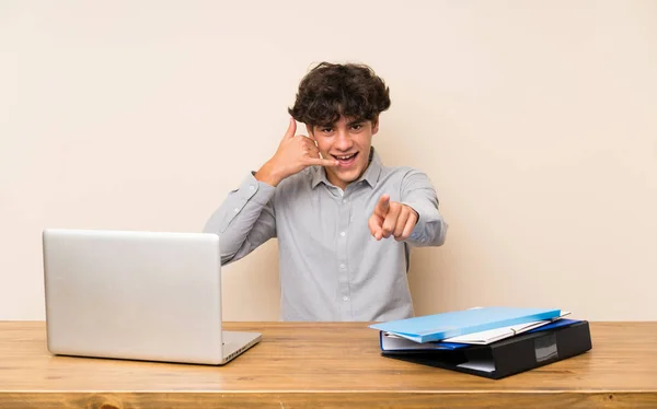 Jovem Estudante Com Laptop Fazendo Gesto Telefone Apontando Frente — Fotografia de Stock