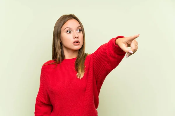 Tiener Meisje Geïsoleerde Groene Achtergrond Wijzend — Stockfoto