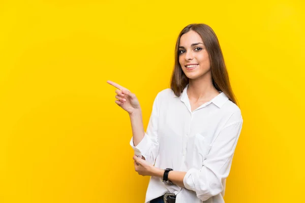 Ung Kvinna Över Isolerad Gul Bakgrund Pekar Finger Sidan — Stockfoto