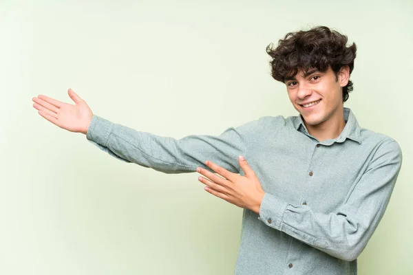 Молодий Чоловік Над Ізольованою Зеленою Стіною Простягає Руки Бік Щоб — стокове фото