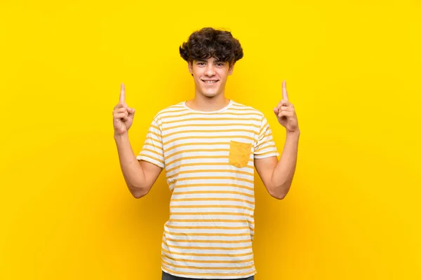 Joven Sobre Aislado Muro Amarillo Señalando Una Gran Idea — Foto de Stock