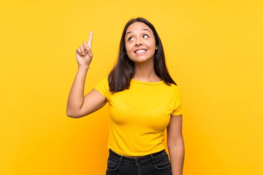 Izole arka plan üzerinde genç esmer kız bir parmak kaldırırken çözüm gerçekleştirmek niyetinde