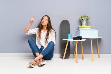 Şeffaf ekrana dokunarak yerde oturan genç kadın