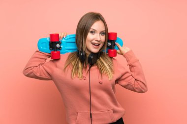 Izole pembe arka plan üzerinde paten ile Genç kız