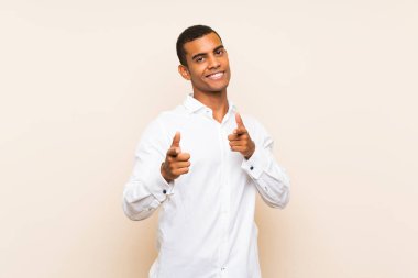 Izole arka plan üzerinde genç yakışıklı esmer adam ön işaret ve gülümseyen