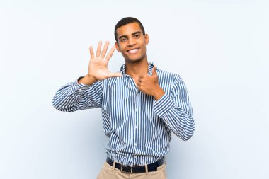 Izole mavi arka plan üzerinde genç yakışıklı esmer adam parmakları ile altı sayma