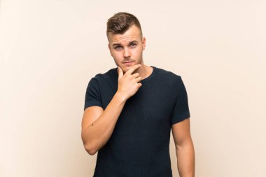 Izole arka plan düşünme üzerinde Genç yakışıklı sarışın adam