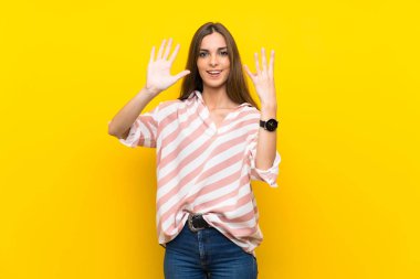 Izole sarı arka plan üzerinde genç kadın parmakları ile dokuz sayma