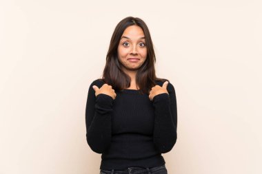 Sürpriz yüz ifadesi ile izole arka plan üzerinde beyaz kazak ile genç esmer kadın