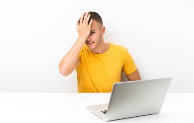 Bir dizüstü bilgisayar ile bir masada genç sarışın adam yüz ifadesi karıştırmayın ile şüpheleri olan