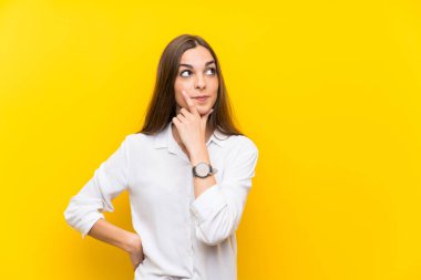 Izole sarı arka plan üzerinde genç kadın bir fikir düşünme