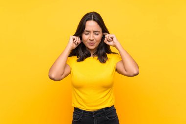 Izole arka plan üzerinde Genç esmer kız sinirli ve kulakları kapsayan