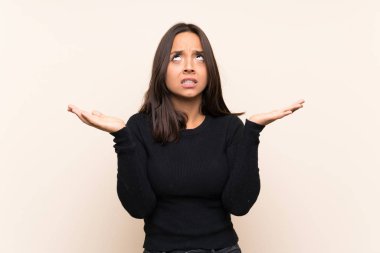 Izole arka plan üzerinde beyaz kazak ile genç esmer kadın kötü bir durum tarafından sinirli