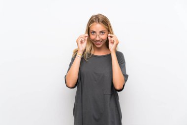 Gözlük lü izole beyaz arka plan üzerinde Sarışın genç kadın ve şaşırttı