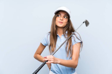 Izole mavi duvar üzerinde genç golfçü kadın omuzları kaldırırken şüphe jest yapma
