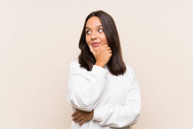 Izole arka plan üzerinde beyaz kazak ile genç esmer kadın bir fikir düşünme