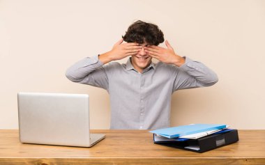 Elleri ile gözleri kaplayan bir dizüstü bilgisayar ile genç öğrenci adam