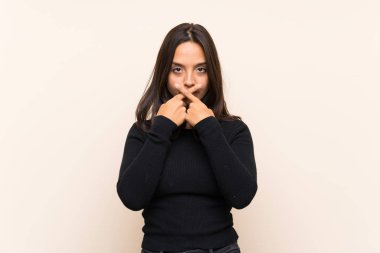 İzole arka plan üzerinde beyaz kazak ile genç esmer kadın sessizlik jest bir işareti gösteren