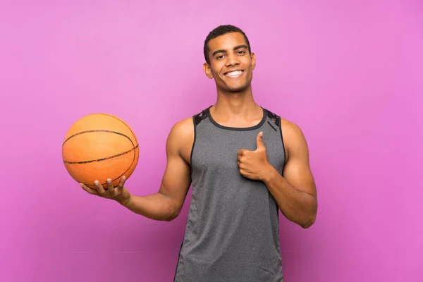 Молодой Спортсмен Мячом Баскетбола Над Изолированной Фиолетовой Стеной Большими Пальцами — стоковое фото