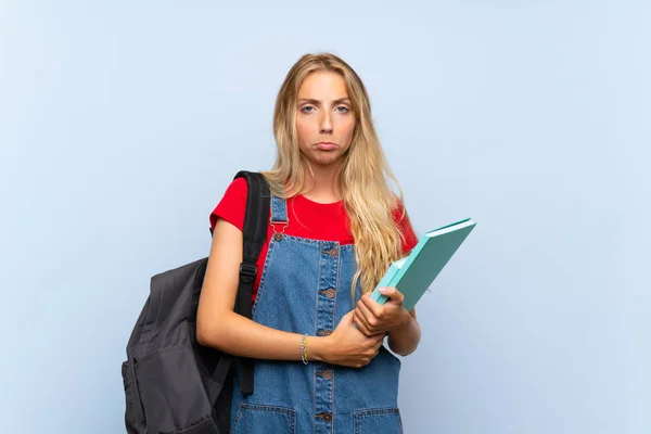 Jonge Blonde Student Vrouw Geïsoleerde Blauwe Muur Triest — Stockfoto