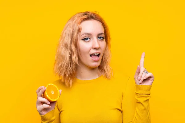 Młoda Kobieta Trzymania Pomarańczowego Białym Tle Żółty Zamierzając Zrealizować Rozwiązanie — Zdjęcie stockowe