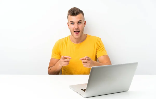 Jovem Loiro Uma Mesa Com Laptop Aponta Dedo Para Você — Fotografia de Stock