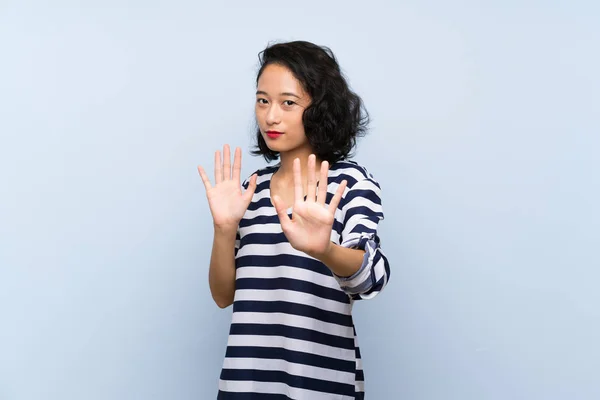 Izole Mavi Arka Plan Sinir Elleri Germe Üzerinde Asyalı Genç — Stok fotoğraf