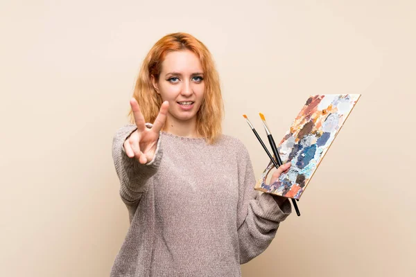 Izole Arka Plan Üzerinde Genç Sanatçı Kadın Gülümseyerek Zafer Işareti — Stok fotoğraf