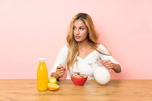 Junge blonde Frau beim Frühstück Milch — Stockfoto