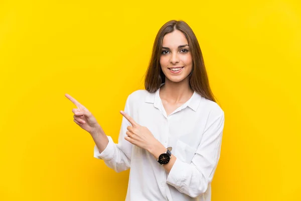 Young Woman Isolated Yellow Background Pointing Finger Side — Stock Photo, Image