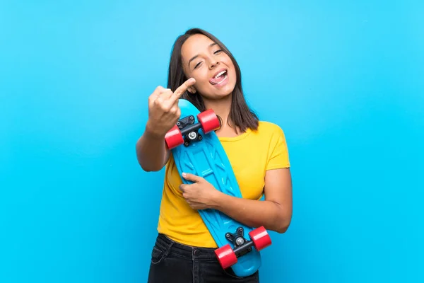 孤立した青い背景の上に若いスケーターの女性 — ストック写真