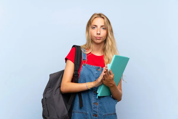 Joven Estudiante Rubia Sobre Aislada Pared Azul Suplicando — Foto de Stock