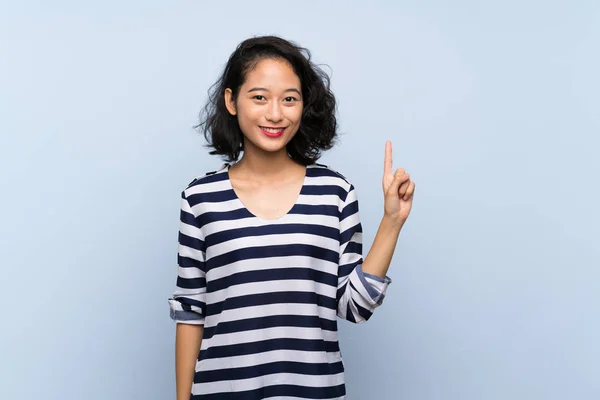 Asiática Jovem Mulher Sobre Isolado Fundo Azul Mostrando Levantando Dedo — Fotografia de Stock