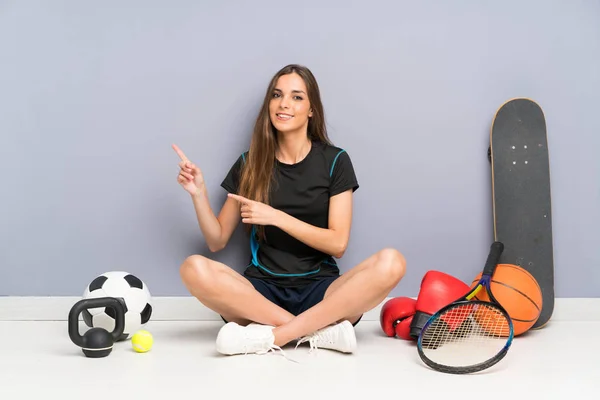 Jovem Mulher Esporte Sentado Chão Apontando Dedo Para Lado — Fotografia de Stock