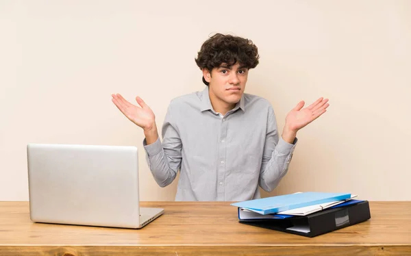 Jeune Étudiant Homme Avec Ordinateur Portable Faisant Des Doutes Geste — Photo