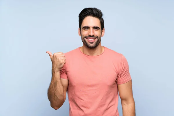 Handsome Young Man Pink Shirt Isolated Blue Background Pointing Side — Stockfoto