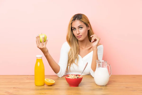 Junge blonde Frau beim Frühstück Milch — Stockfoto