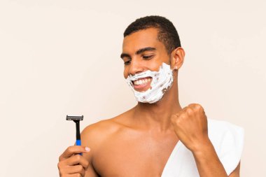 Genç yakışıklı adam bir zafer kutluyor izole arka plan üzerinde sakalTıraş