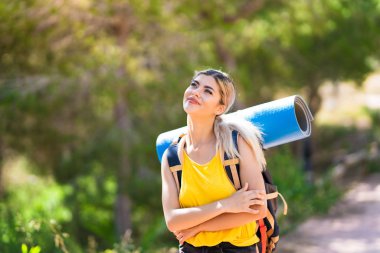 Genç kız gülümseyerek açık havada yürüyüş yukarı bakıyor