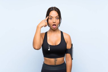 Izole mavi arka plan üzerinde genç spor kız çözüm gerçekleştirmek niyetinde